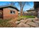 View of the brick detached garage in the backyard, with grass and stone walkway at 618 Adams St, Denver, CO 80206