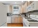 Kitchen with white appliances, light wood cabinets, and a window at 618 Adams St, Denver, CO 80206