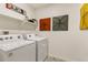 Convenient laundry room with washer, dryer, and shelving at 6531 13Th St, Frederick, CO 80530