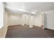 Finished basement with gray carpeting, white walls, and access to additional storage space and rooms at 7527 E Severn Pl, Denver, CO 80230