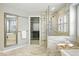 Elegant bathroom featuring a soaking tub, glass enclosed shower, and walk-in closet access at 7527 E Severn Pl, Denver, CO 80230