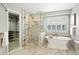 Luxurious bathroom featuring a soaking tub, glass enclosed shower, and walk-in closet access at 7527 E Severn Pl, Denver, CO 80230