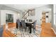 Elegant dining room with hardwood floors, modern table, and staircase view at 7527 E Severn Pl, Denver, CO 80230
