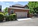 Brick home with a two-car garage, black iron fencing, and mature landscaping at 7527 E Severn Pl, Denver, CO 80230