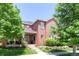Inviting two-story brick home featuring a well-manicured lawn and mature trees at 7527 E Severn Pl, Denver, CO 80230