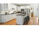 Modern kitchen with white cabinets, an island with bar stools, and hardwood flooring at 7527 E Severn Pl, Denver, CO 80230