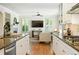 Open kitchen with granite counters, white cabinetry, and stainless steel appliances overlooks the living room at 7527 E Severn Pl, Denver, CO 80230