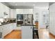 Well-lit kitchen featuring white cabinetry, stainless steel appliances, and a breakfast bar at 7527 E Severn Pl, Denver, CO 80230