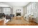 Bright living room featuring hardwood floors, a fireplace, and large windows with shutters at 7527 E Severn Pl, Denver, CO 80230