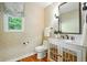 Stylish powder room features patterned wallpaper, a decorative vanity, and a window at 7527 E Severn Pl, Denver, CO 80230