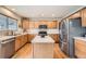 Well-lit kitchen featuring wood cabinets, stainless steel appliances, and a tiled island at 6172 S Salida Ct, Aurora, CO 80016