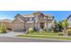 Attractive two-story home displaying a lush front yard, stone and siding facade, and a spacious three-car garage at 22198 Boundstone Dr, Parker, CO 80138