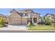 Gorgeous two-story home with a well-kept front yard, stone and siding exterior, and a convenient three-car garage at 22198 Boundstone Dr, Parker, CO 80138