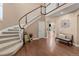 Elegant foyer featuring a curved staircase, hardwood floors, and stylish decor at 22198 Boundstone Dr, Parker, CO 80138