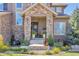Charming front porch enhanced with stone pillars, a water feature, landscaping, and a cozy seating area at 22198 Boundstone Dr, Parker, CO 80138