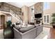 Bright living room featuring a stone fireplace, tall windows, and sectional sofa at 22198 Boundstone Dr, Parker, CO 80138