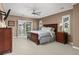 Spacious main bedroom with sliding doors to deck, plush carpet, and a large bed at 22198 Boundstone Dr, Parker, CO 80138