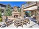 Inviting outdoor living space featuring a stone fireplace, comfortable seating, and a built-in grill for entertaining at 22198 Boundstone Dr, Parker, CO 80138
