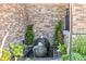 Close-up of a decorative stone fountain amidst lush greenery, adding a tranquil touch to the home's entrance at 22198 Boundstone Dr, Parker, CO 80138