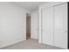 Cozy bedroom featuring double closets, neutral carpet, and modern white trim at 45946 Gentry Ave, Bennett, CO 80102