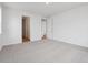 Empty bedroom with neutral carpet, white walls and two open doorways at 45946 Gentry Ave, Bennett, CO 80102