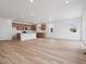 Open floor plan, luxury vinyl flooring, and eat-in island featuring bar seating at 45946 Gentry Ave, Bennett, CO 80102