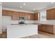 Modern kitchen with stainless steel appliances, quartz countertops, and a center island with breakfast bar at 45946 Gentry Ave, Bennett, CO 80102