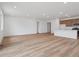 Open-concept living space featuring wood-look floors and seamless flow to the kitchen with breakfast bar at 45946 Gentry Ave, Bennett, CO 80102