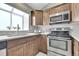 Updated kitchen with stainless steel appliances, wood cabinets, and large window at 17336 E Rice Cir # F, Aurora, CO 80015