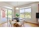 Bright dining area with a modern round table and views of the backyard at 16283 Olive Way, Brighton, CO 80602