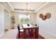Formal dining room with a tray ceiling, modern chandelier, and a large window at 16283 Olive Way, Brighton, CO 80602