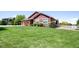 Landscaped front yard of this home has vibrant green lawn and well-maintained shrubbery at 16283 Olive Way, Brighton, CO 80602
