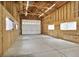 Large garage featuring high ceilings, concrete flooring and a roll up door at 16283 Olive Way, Brighton, CO 80602