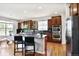 An open kitchen features an island with bar seating, stainless steel appliances, and wood cabinets at 16283 Olive Way, Brighton, CO 80602