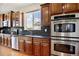 Modern kitchen features stainless steel appliances, a large window, and wood cabinets at 16283 Olive Way, Brighton, CO 80602