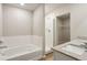 Well-lit bathroom with a soaking tub, walk-in shower, and double sink vanity at 48220 Shetland Dr, Bennett, CO 80102