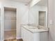 Bathroom with double sink vanity, large mirror, and a walk-in closet at 48220 Shetland Dr, Bennett, CO 80102