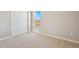 Bright bedroom with neutral carpet, a window with a view, and closet with sliding doors at 48220 Shetland Dr, Bennett, CO 80102