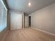 Bedroom featuring neutral carpeting and walls, a large window, and a closet with sliding doors at 48220 Shetland Dr, Bennett, CO 80102