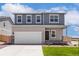Charming two-story home with a well-manicured lawn, two car garage and inviting front porch at 48220 Shetland Dr, Bennett, CO 80102