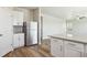 Bright kitchen with white cabinets, stainless steel appliances and adjacent living area at 48220 Shetland Dr, Bennett, CO 80102