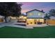 A beautifully landscaped backyard featuring an expansive patio, a lush lawn, and a charming wooden deck at 15034 E Floyd Ave, Aurora, CO 80014