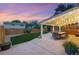 Outdoor patio with string lights, dining table, and a well-maintained lawn for relaxing and entertaining at 15034 E Floyd Ave, Aurora, CO 80014