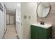 Bathroom with green vanity and round mirror at 15034 E Floyd Ave, Aurora, CO 80014