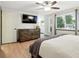 Bedroom with a ceiling fan, dresser, and a large window providing natural light at 15034 E Floyd Ave, Aurora, CO 80014