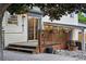 Wooden deck with stairs, flower pots, stone landscaping, and string lights along the patio cover at 15034 E Floyd Ave, Aurora, CO 80014