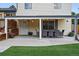 Covered patio with an outdoor dining set, decorative plants, and access to the house at 15034 E Floyd Ave, Aurora, CO 80014