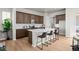 Modern kitchen featuring wood cabinets, a large kitchen island with seating, and stainless steel appliances at 5928 N Lisbon St, Aurora, CO 80019