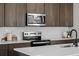 Kitchen detail highlighting stainless steel appliances, white subway tile backsplash, and wood cabinets at 5928 N Lisbon St, Aurora, CO 80019