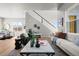 Open-concept living room with hardwood floors, a cozy sofa, lots of natural light, and staircase at 5928 N Lisbon St, Aurora, CO 80019